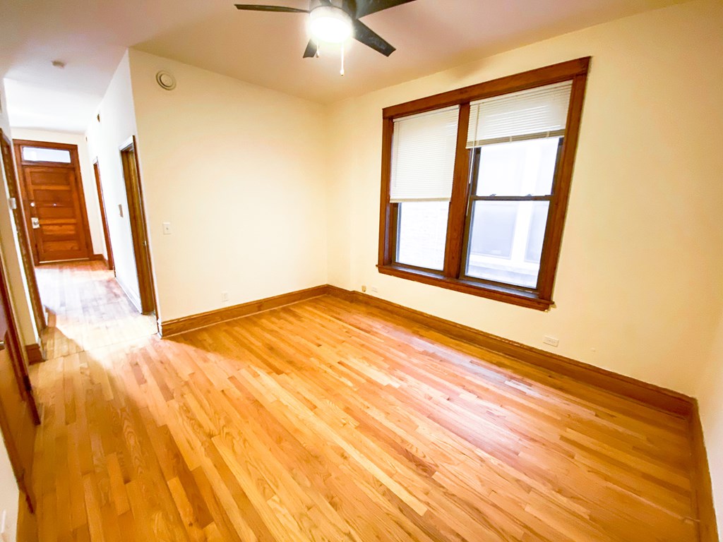 A room with wooden flooring and a window.