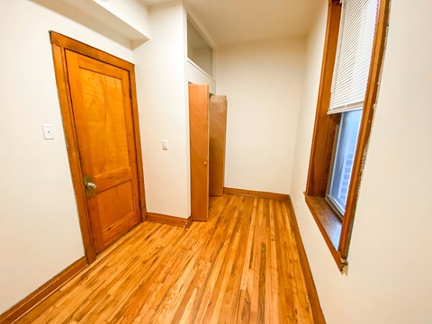 A room with a wooden floor and a wooden door.