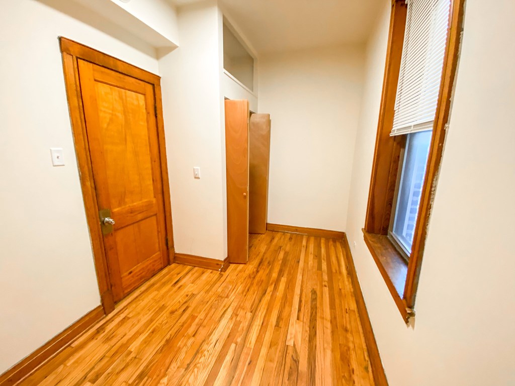 A room with a wooden floor and a wooden door.