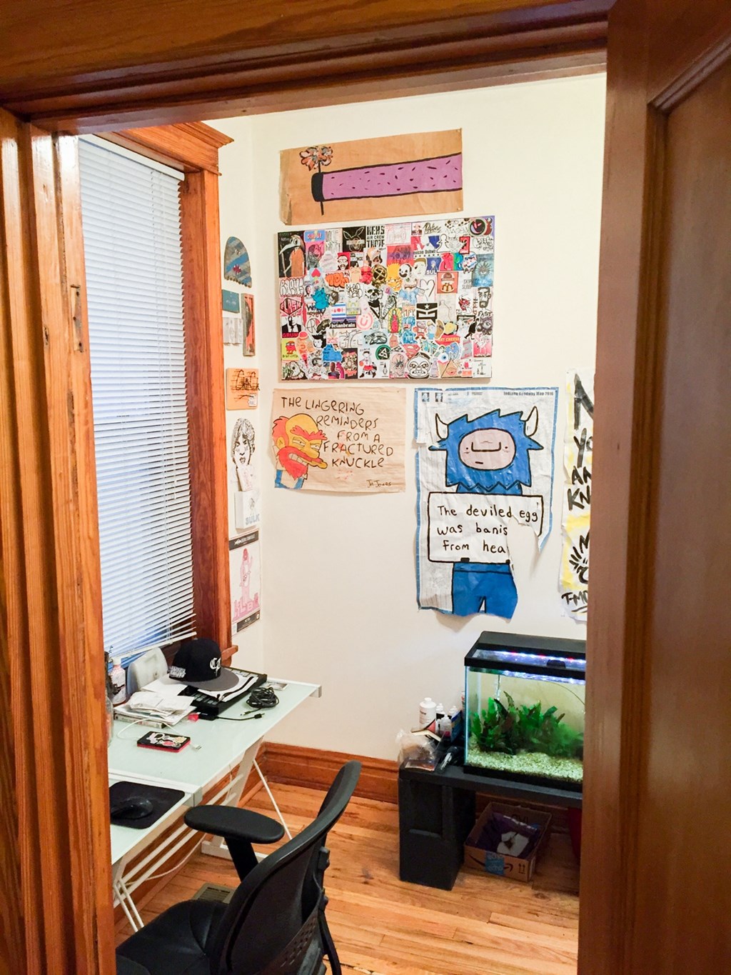 a cluttered room with a fish tank and a desk