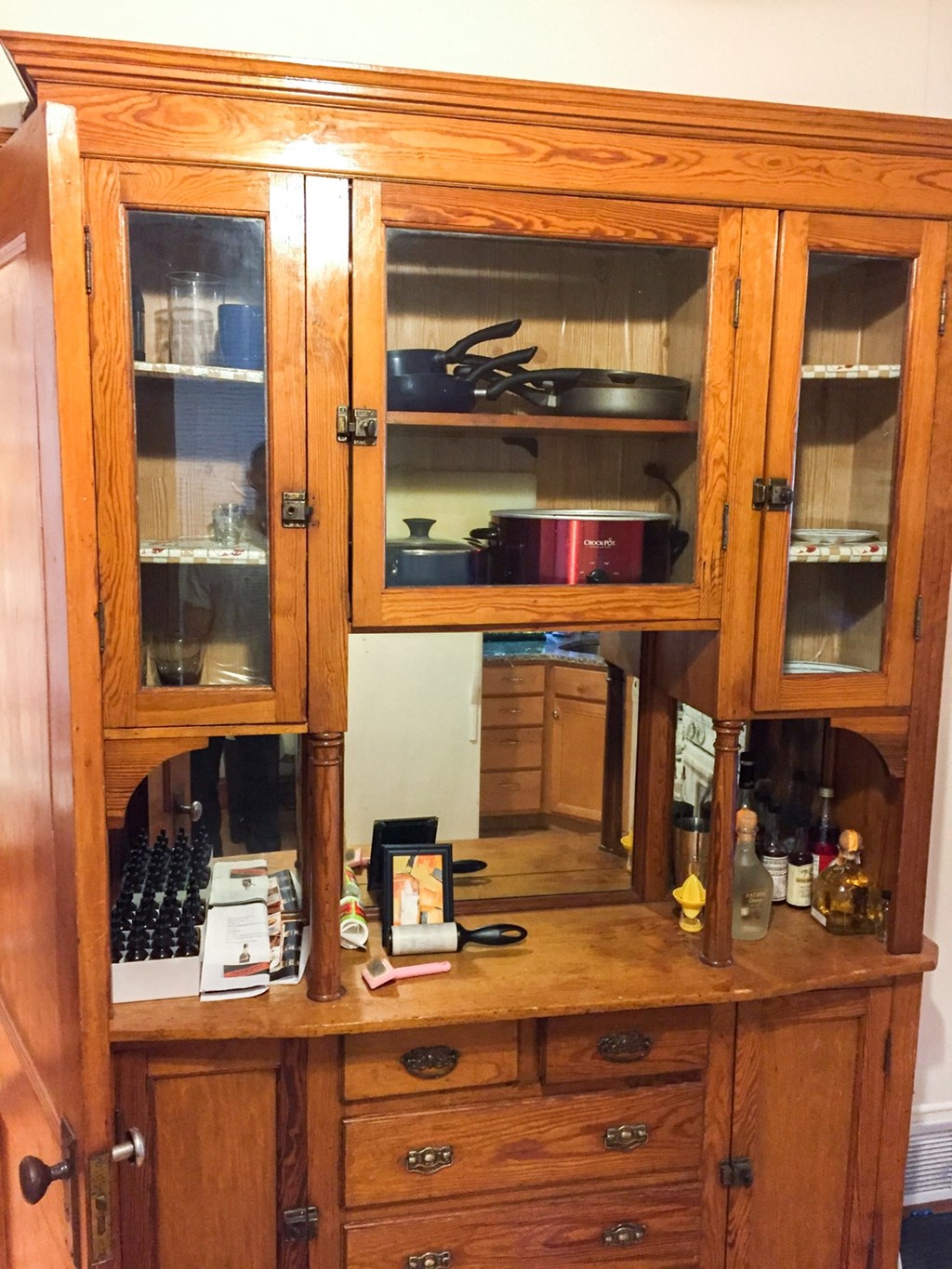 an old wooden cabinet with glass doors and drawers