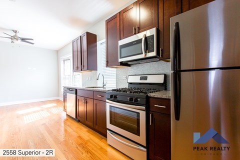 A kitchen with a refrigerator, stove, and microwave.