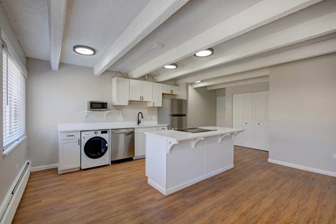 A kitchen with white cabinets and a wooden floor.