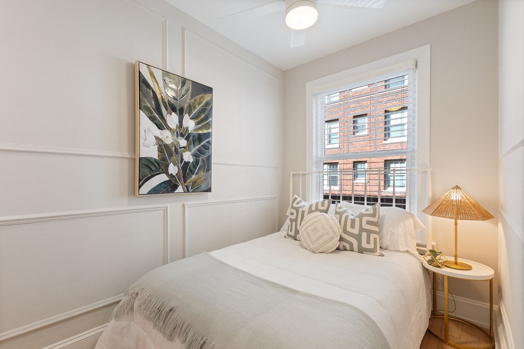 a small bedroom with a bed and a window