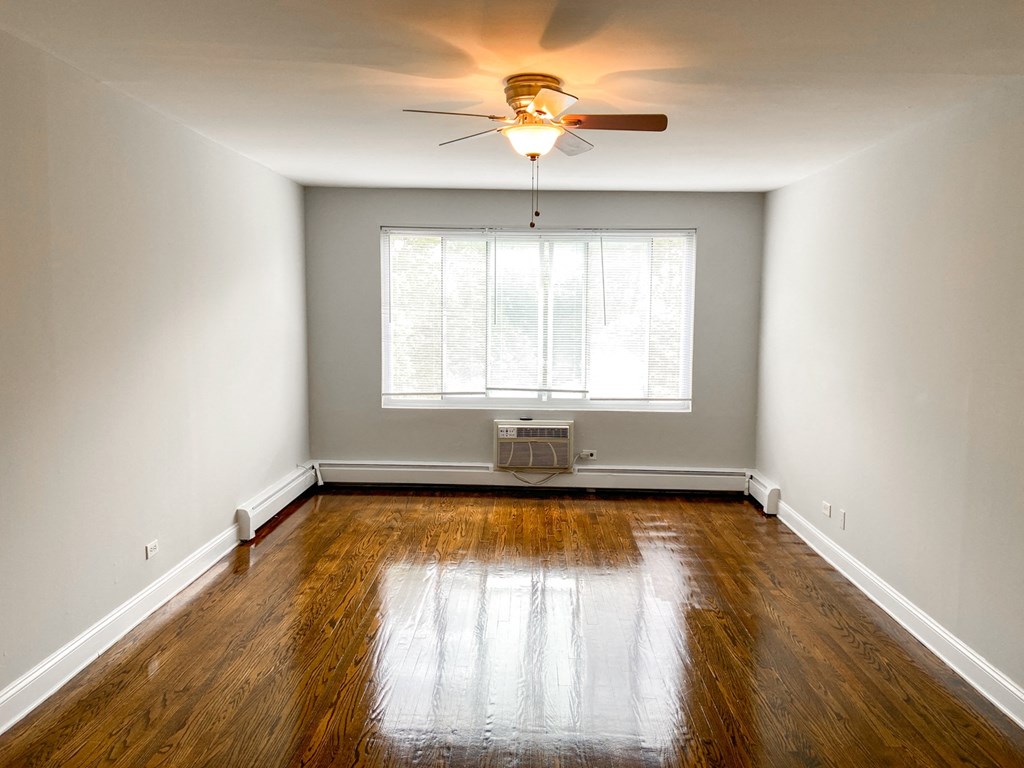 an empty room with a ceiling fan and a window