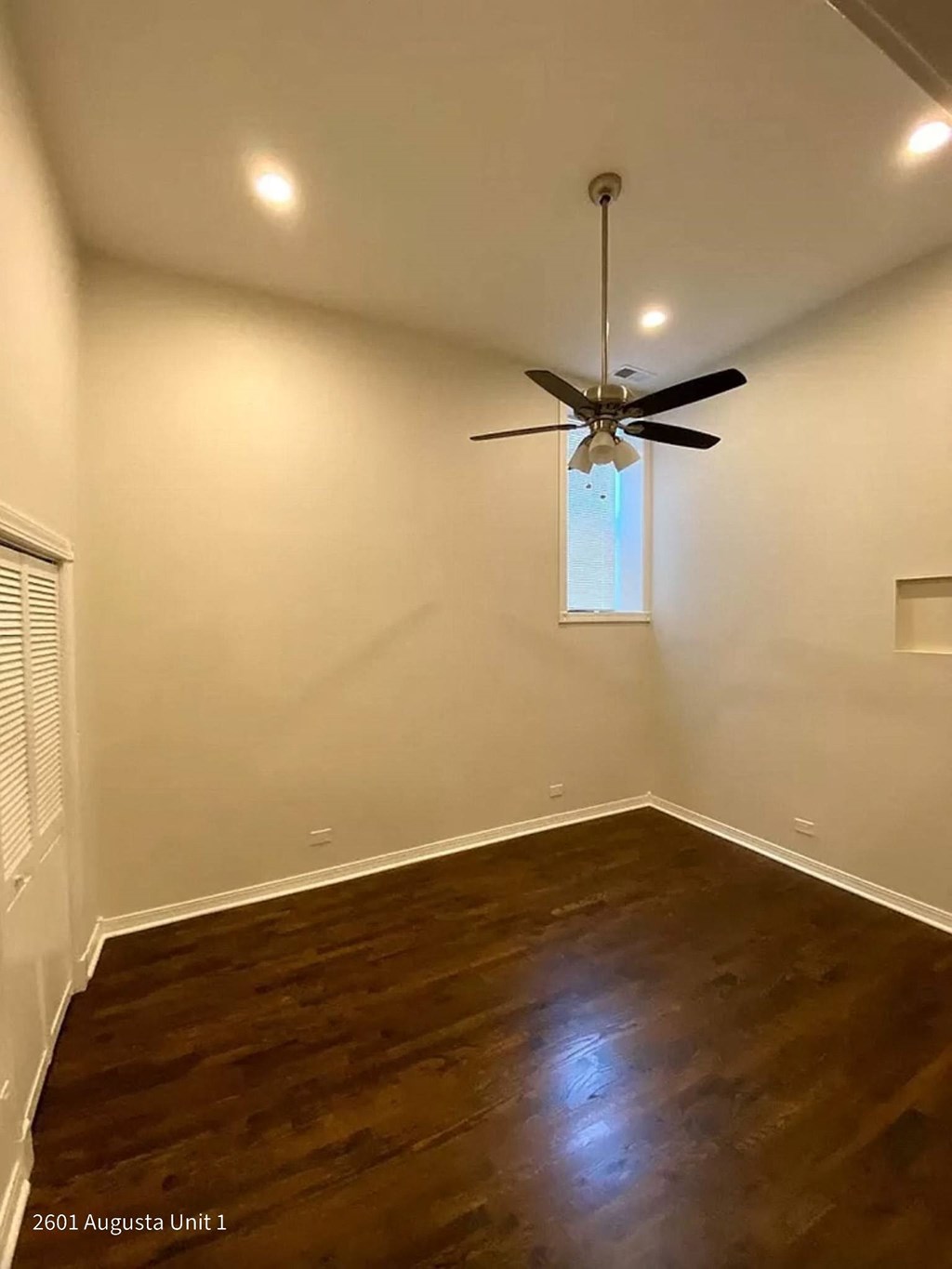 a empty room with a ceiling fan and a window