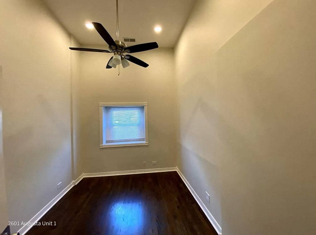 a empty room with a ceiling fan and a window