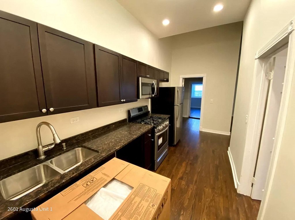 a kitchen with a sink and a counter with a cardboard box