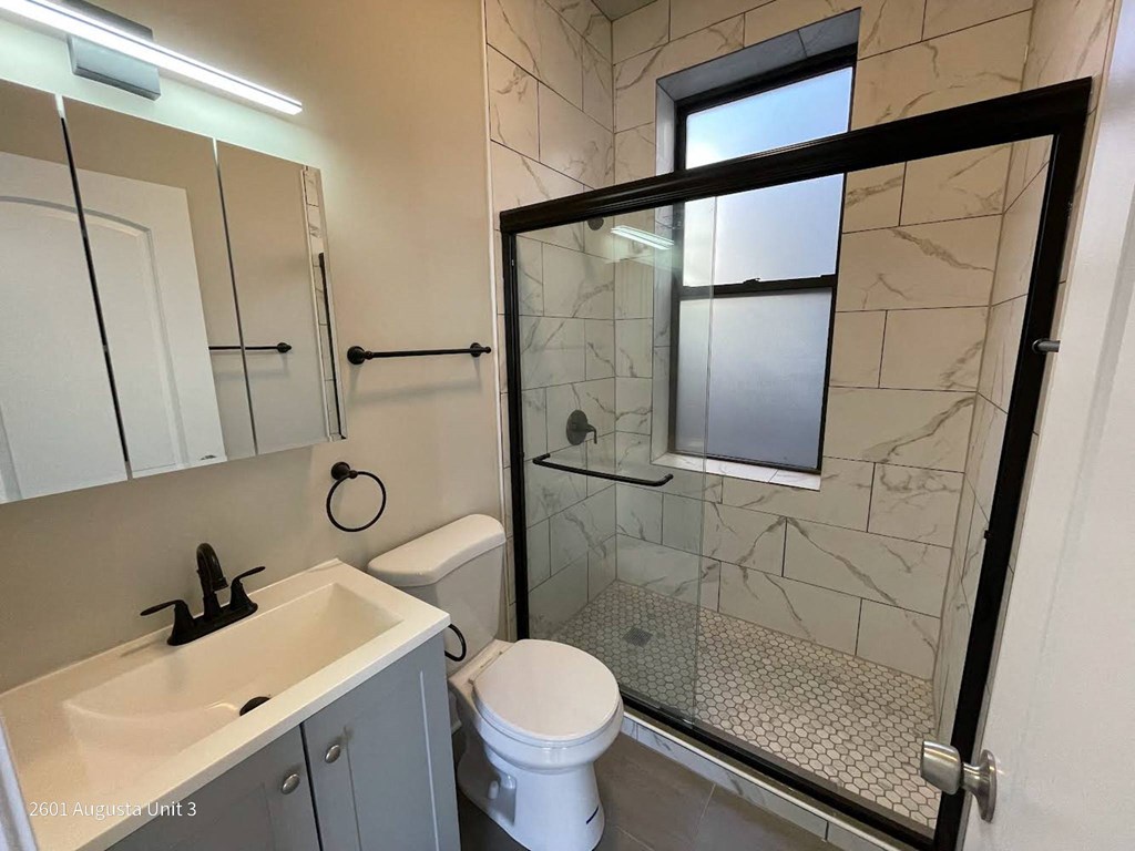 a bathroom with a toilet and a sink and a shower