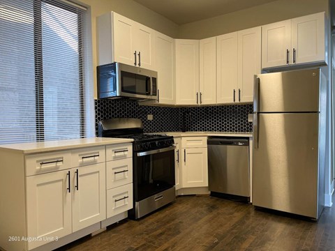 a kitchen with stainless steel appliances and white cabinets