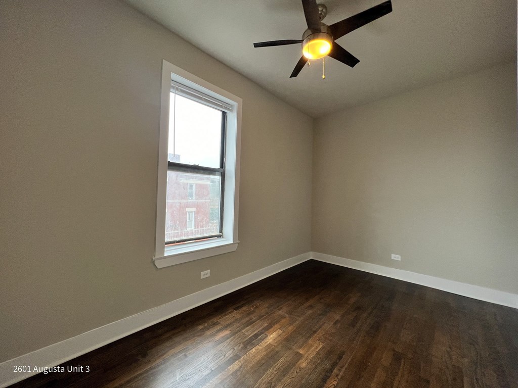 an empty room with a ceiling fan and a window