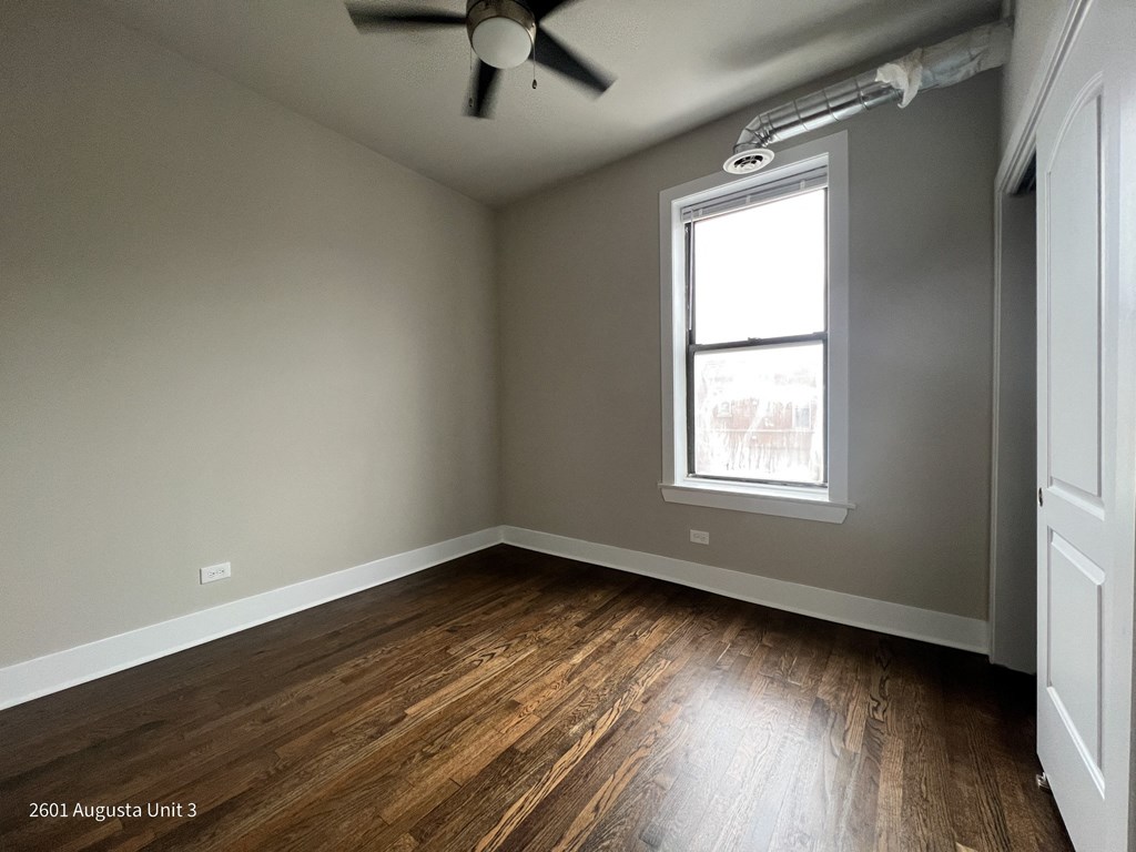 an empty room with wood floors and a window