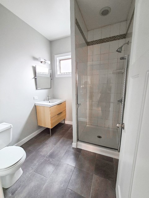 A bathroom with a toilet, sink, and walk-in shower.