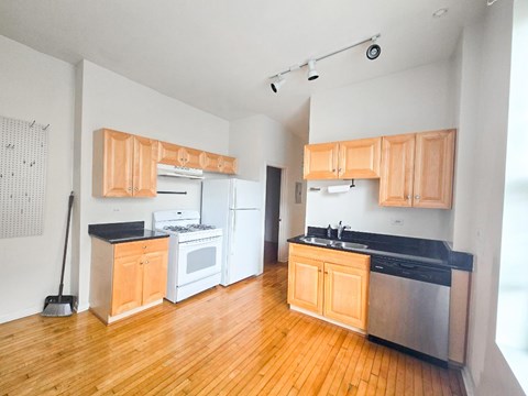 A kitchen with wooden cabinets and a black countertop.