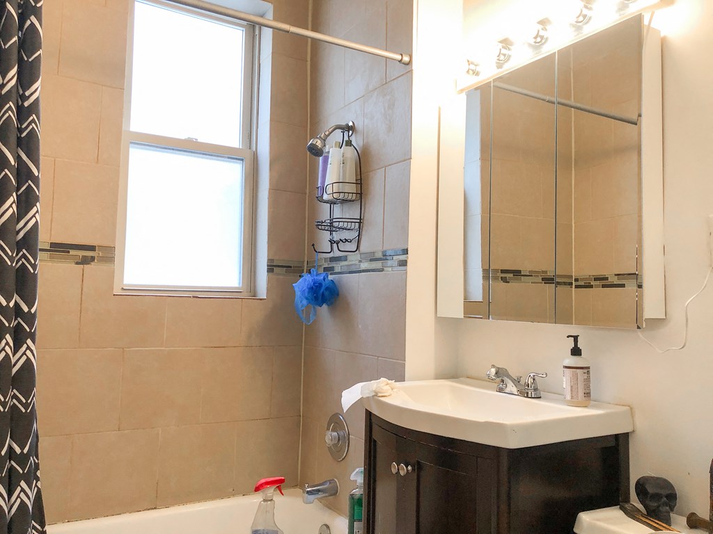 a small bathroom with a sink and a shower and a mirror