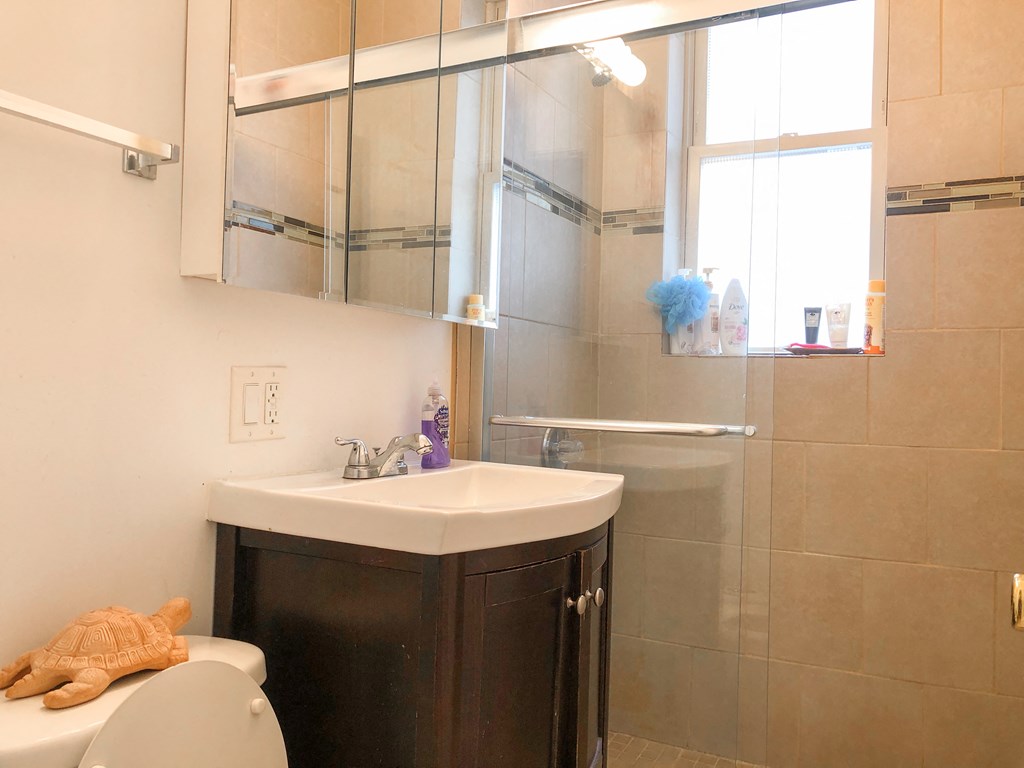 a small bathroom with a sink toilet and shower