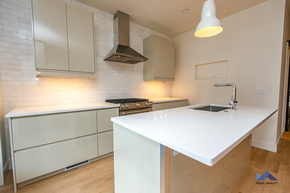 a kitchen with a white counter top and a sink