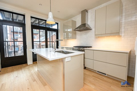 a white kitchen with a sink and a window