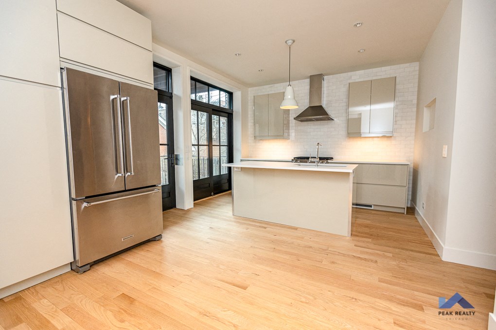 a renovated kitchen with stainless steel appliances and a white island