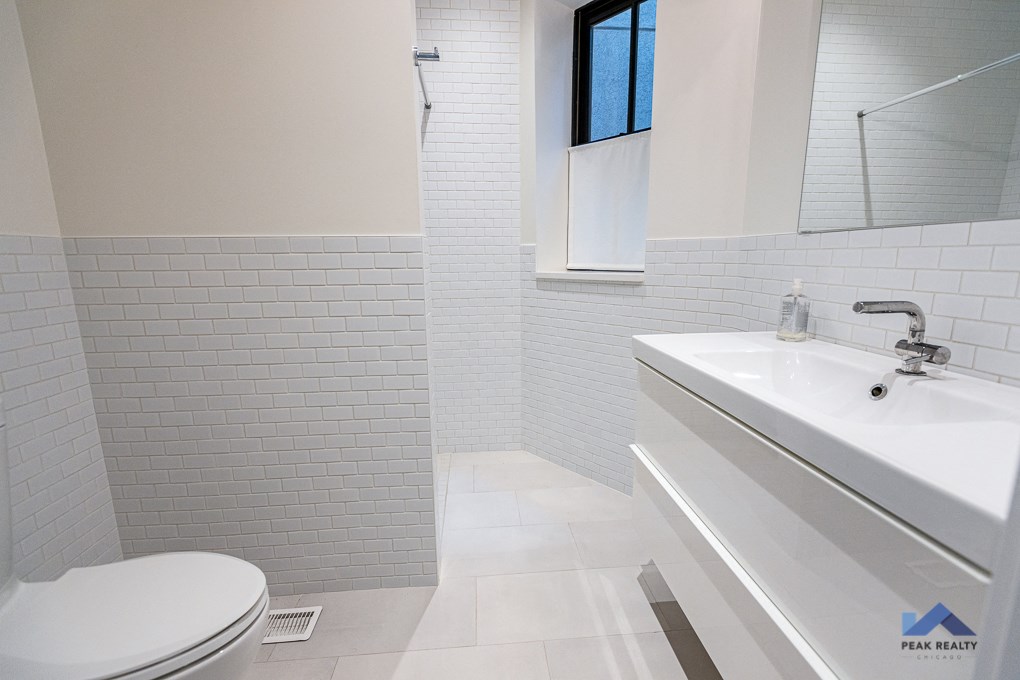 a white bathroom with a toilet and a sink