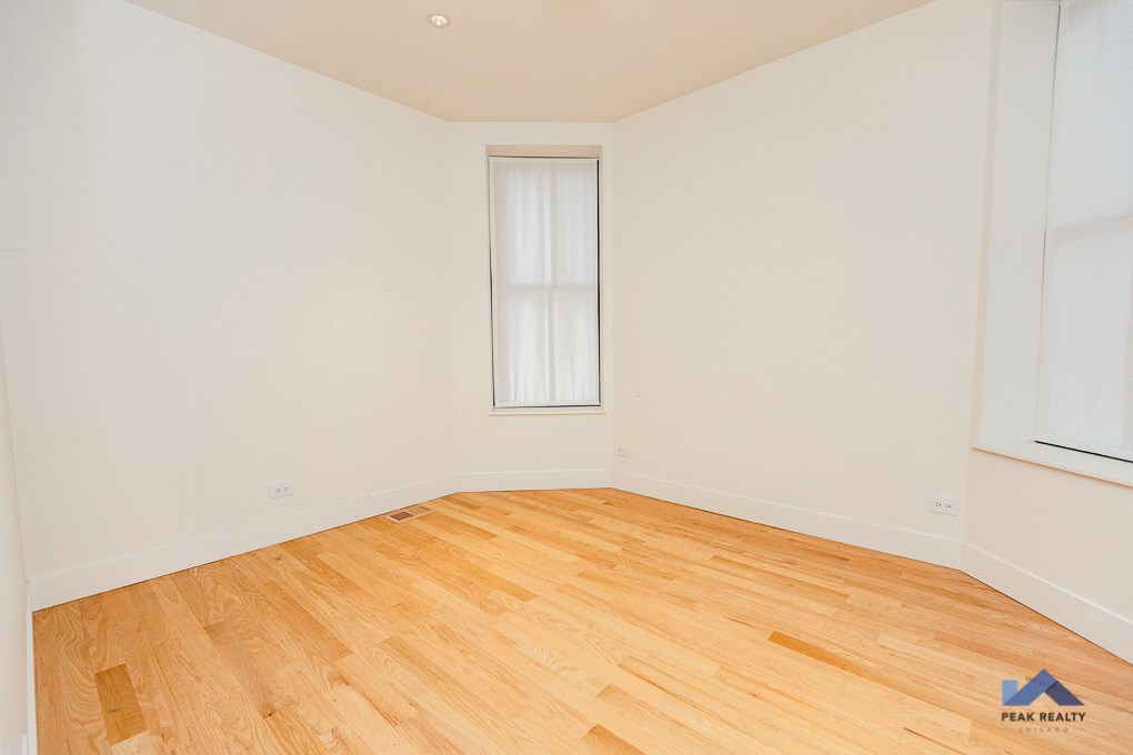 an empty room with wood floors and a window