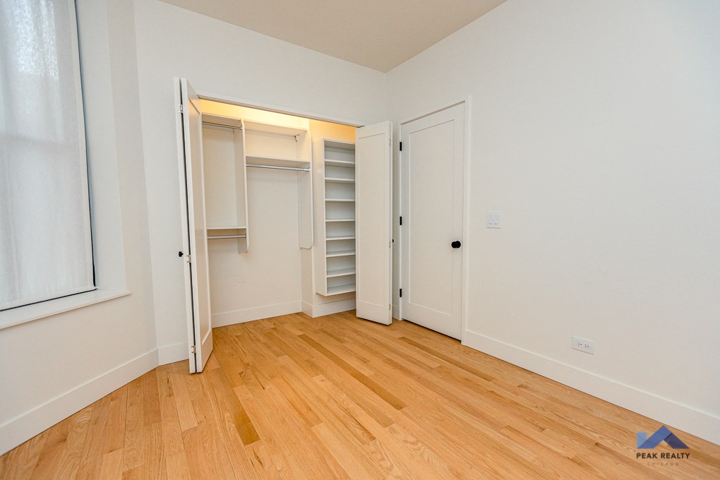 a bedroom with a closet and a hard wood floor