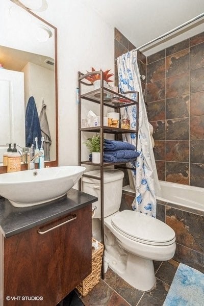 a bathroom with a toilet and a sink and a shower