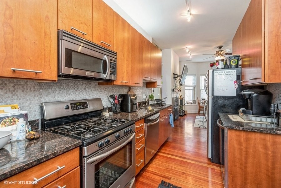 a kitchen with stainless steel appliances and wooden cabinets