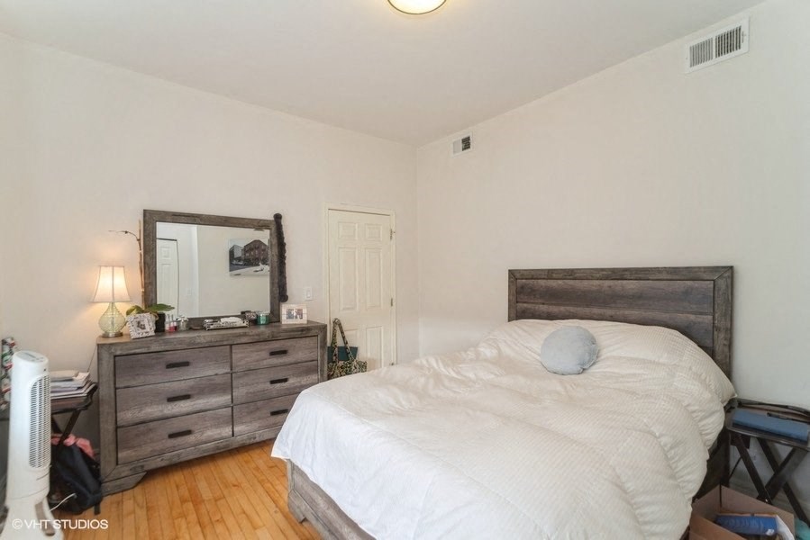 a bedroom with a bed and a dresser with a mirror