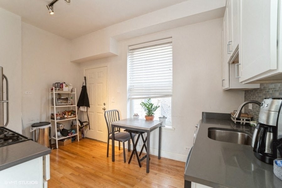 a kitchen with a table and a sink and a window
