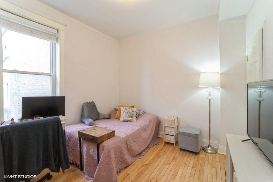 a bedroom with a bed and a tv and a window