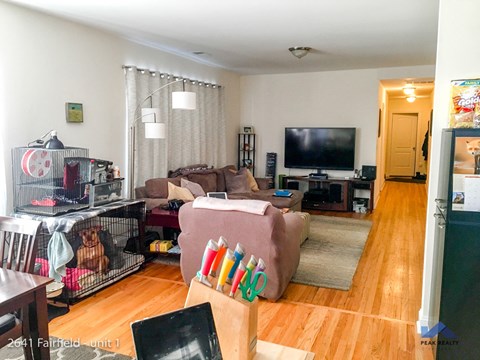 A living room with a couch, chair, and television.