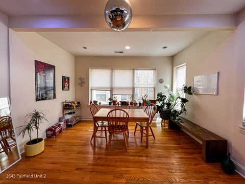 a dining room with a table and chairs and a large window