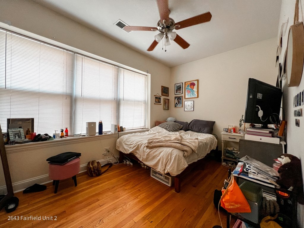 a bedroom with a bed and a ceiling fan