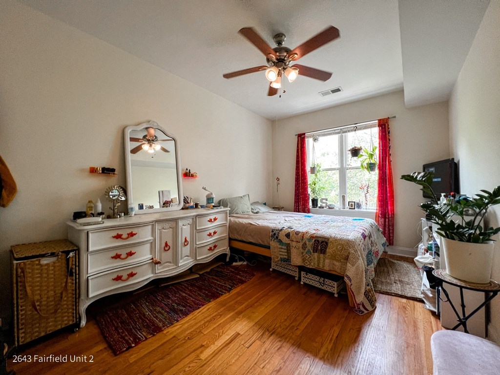 a bedroom with a bed and a ceiling fan