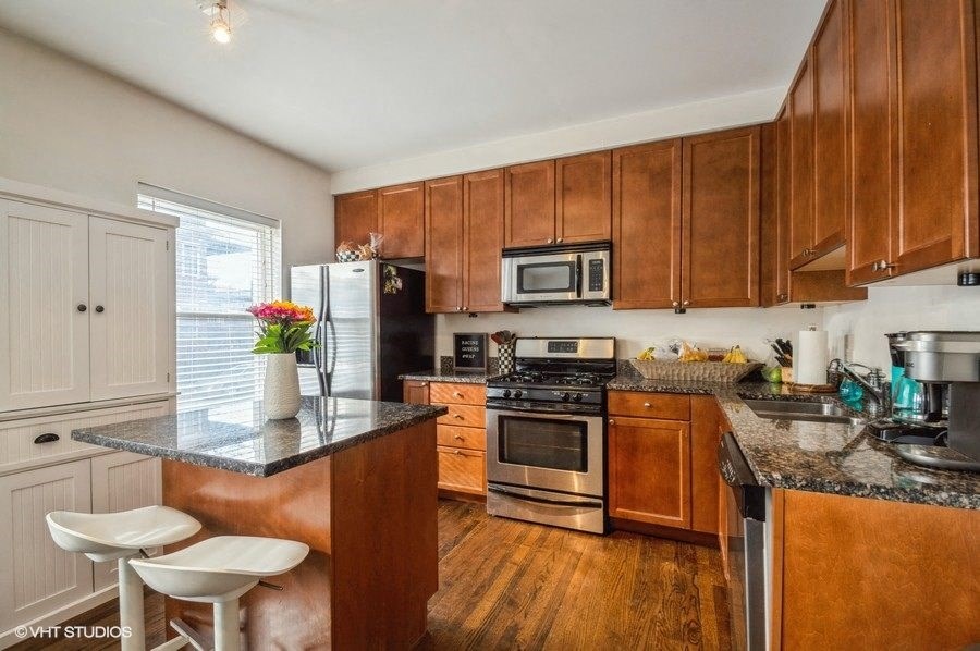 a kitchen with wooden cabinets and stainless steel appliances