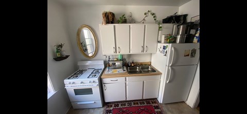 A small kitchen with a white stove and white refrigerator.