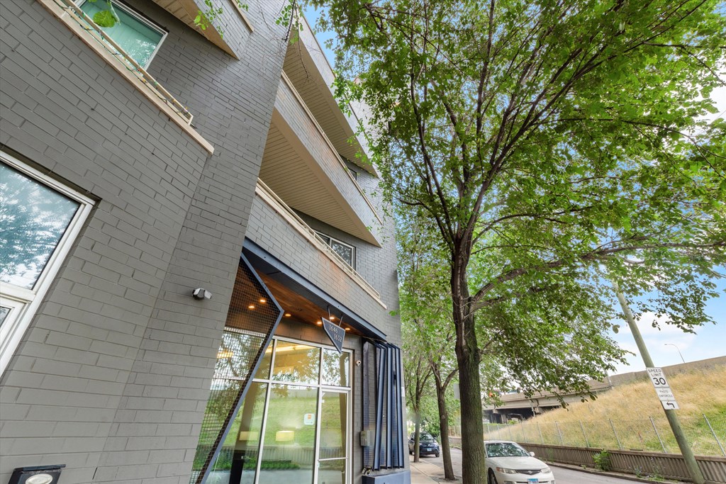 a gray building with a tree in front of it
