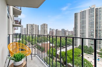 a balcony with a wicker chair and a view of the city