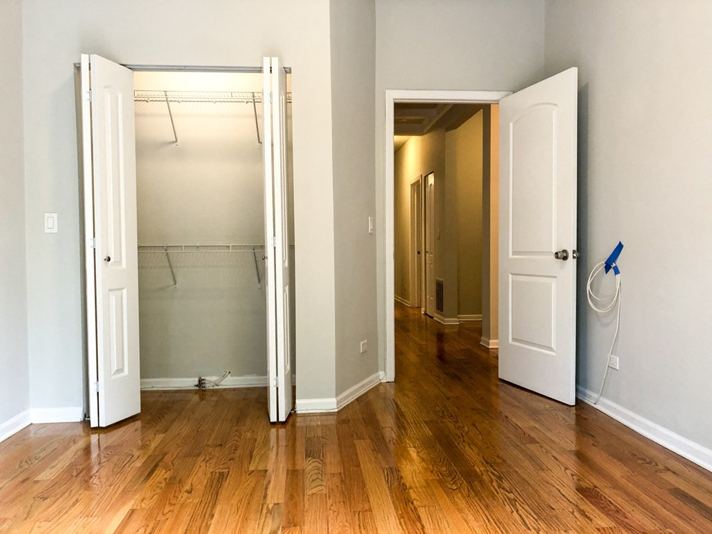 an empty room with a closet and a door open to a bathroom