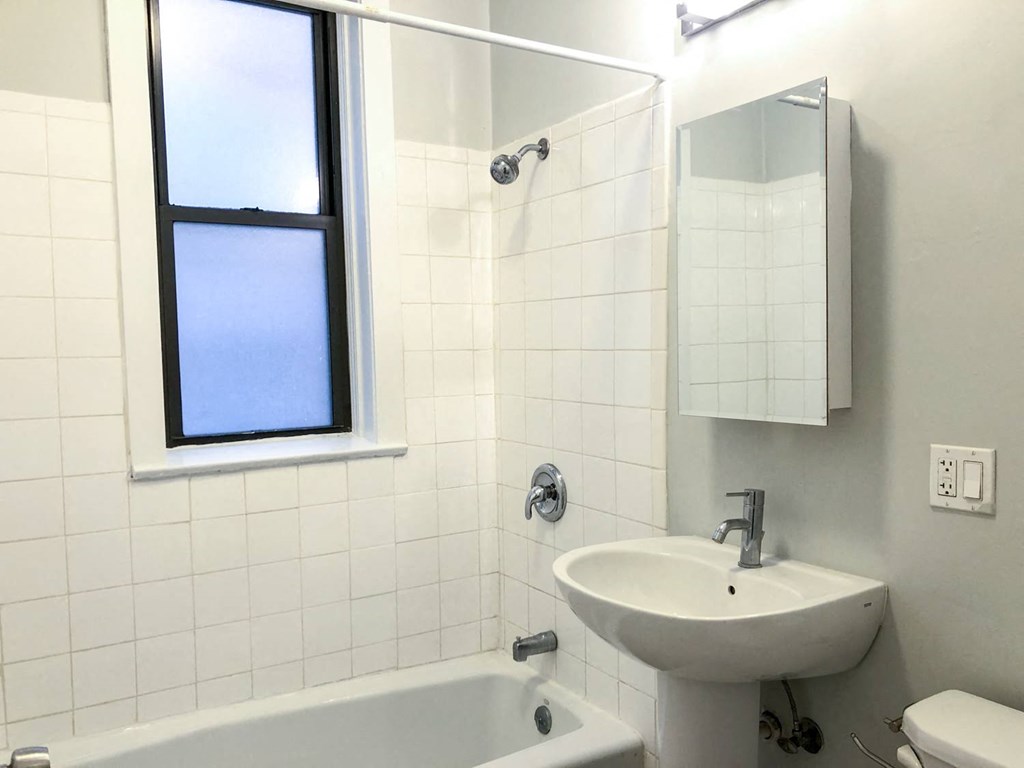 a bathroom with a sink and a bath tub and a window