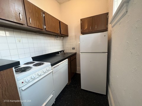 A kitchen with a white stove and a white fridge.