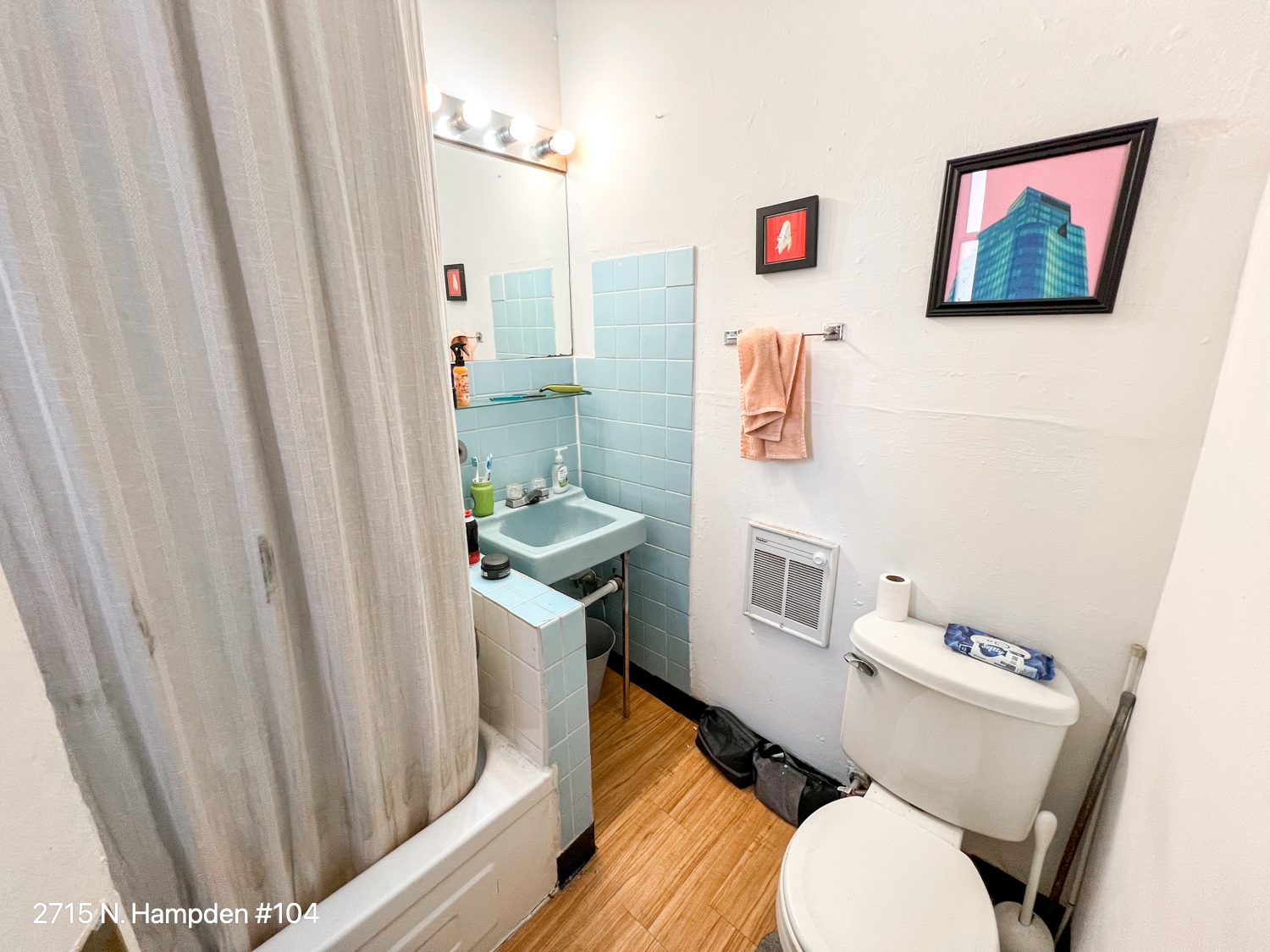 A small bathroom with a toilet, sink, and shower.