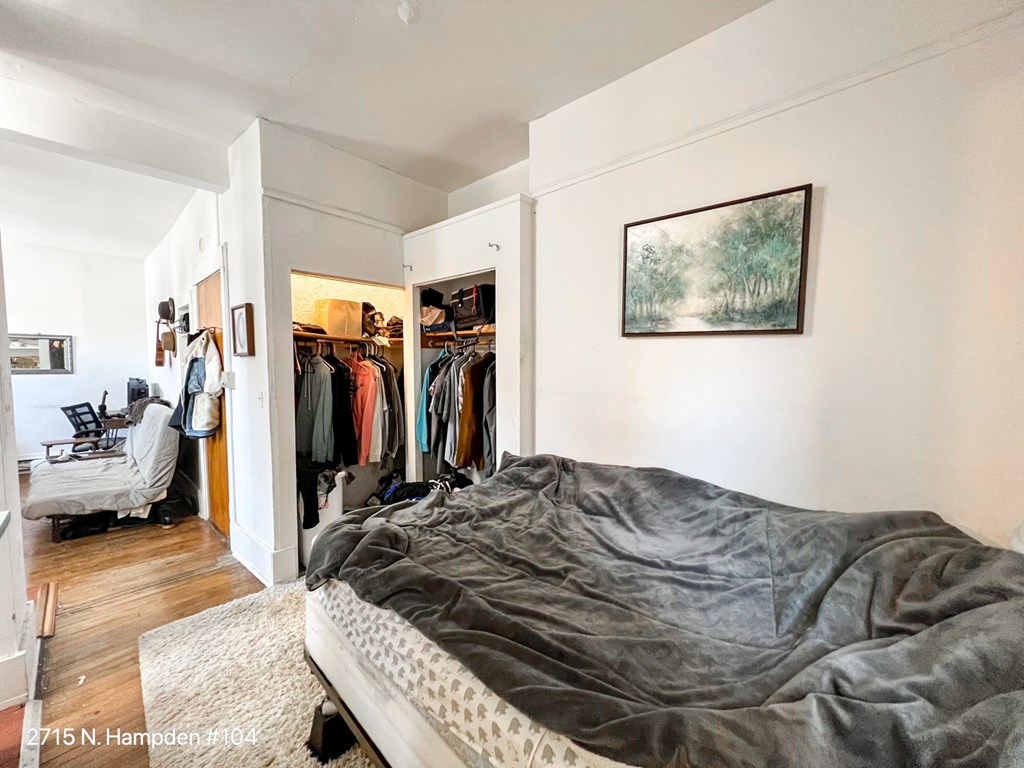a bedroom with an unmade bed and a walk in closet