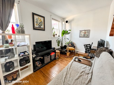 A living room with a grey couch and a black television.