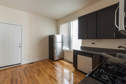 A kitchen with a stove top oven and a refrigerator.