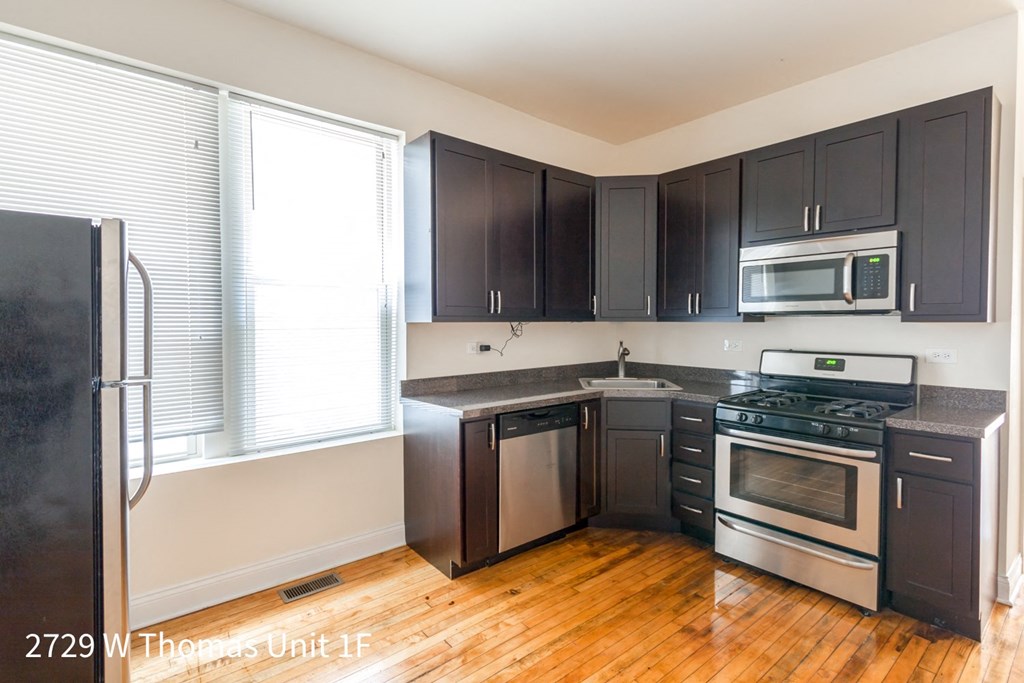 a kitchen with black cabinets and stainless steel appliances