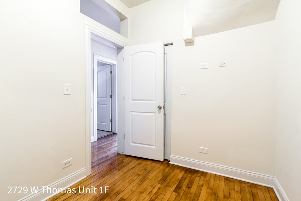 the interior of a home with a wooden floor and white walls