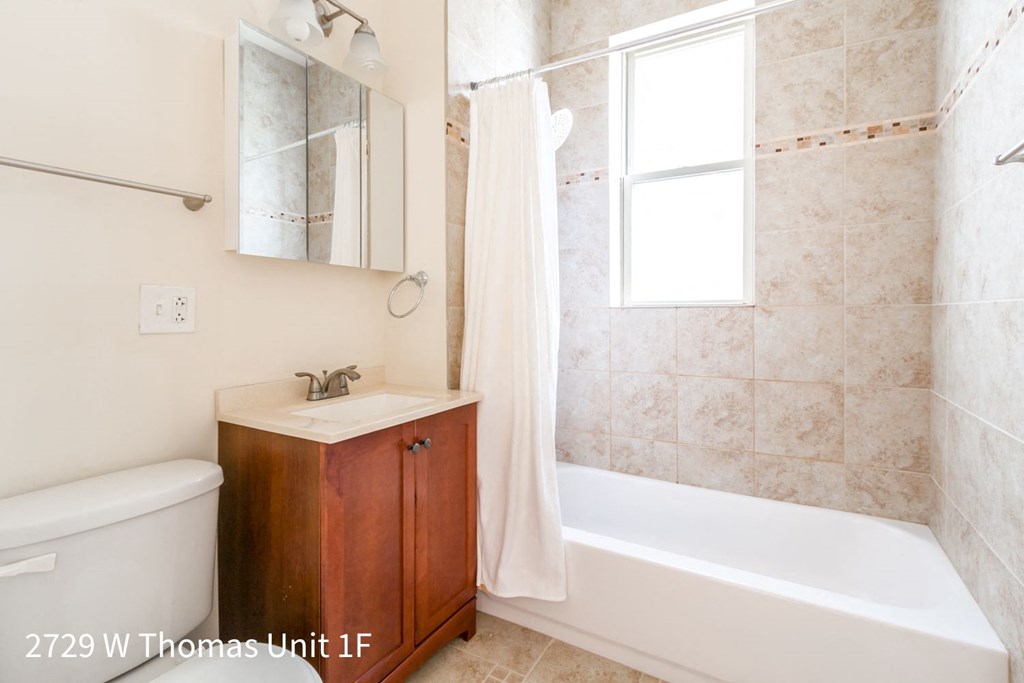 a small bathroom with a tub and a sink and a mirror
