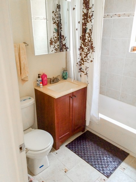 A bathroom with a toilet, sink, and shower.